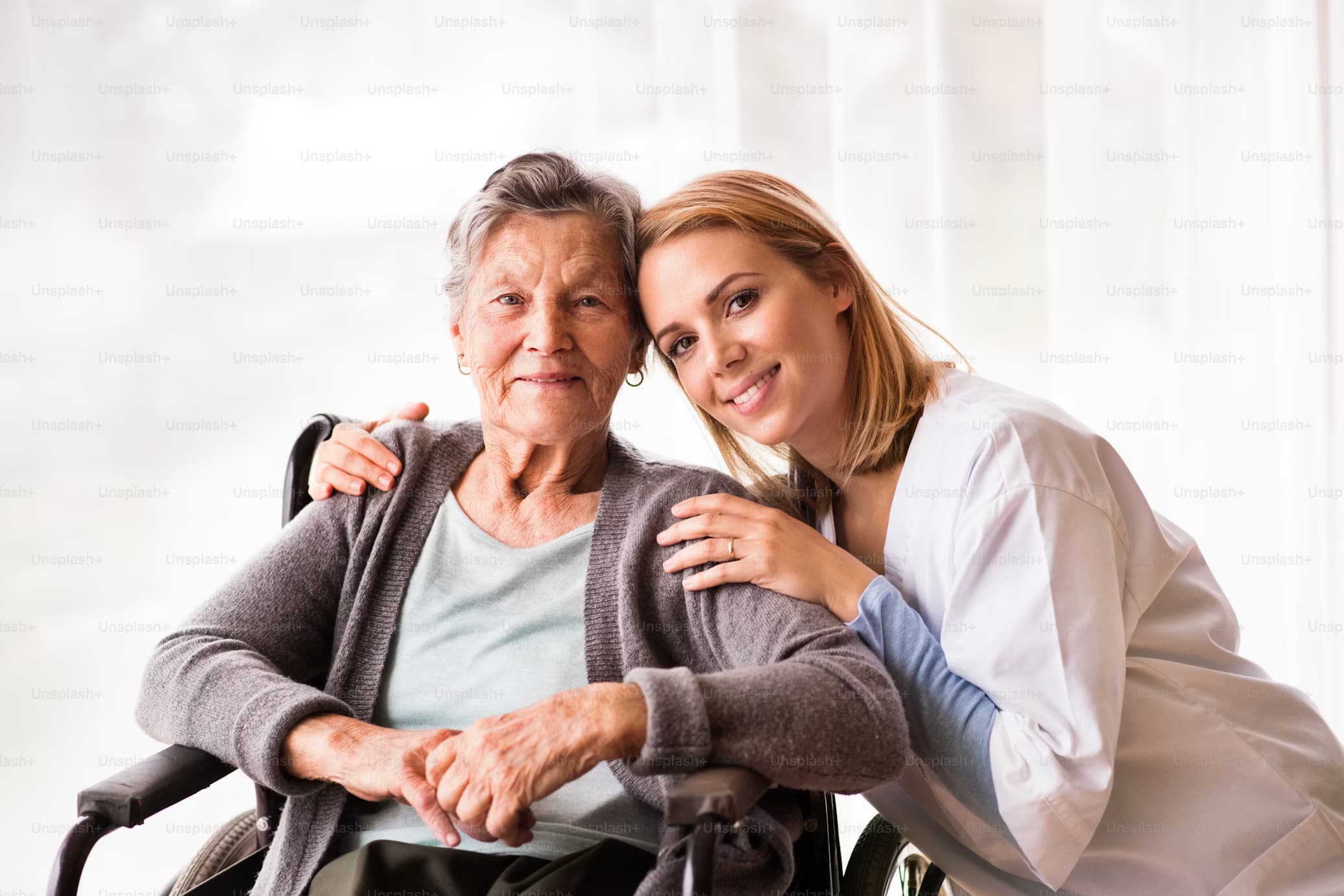 A home health nurse smiling warmly with a senior woman during a visit